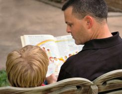 Father reading a book to his son